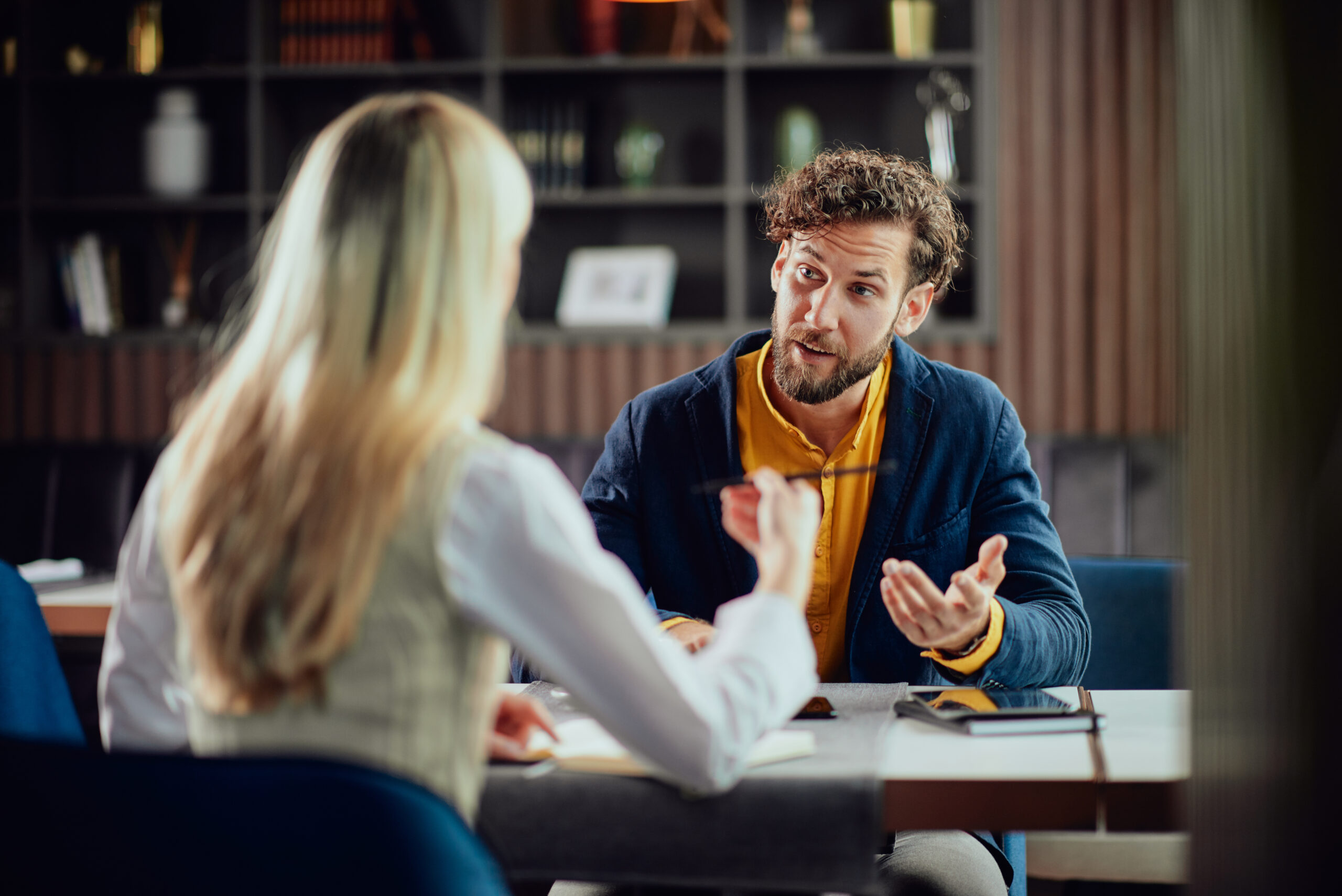 two young attractive colleagues sitting in cafetaria and talking about project. two young attractive colleagues sitting in cafetaria and talking about project.